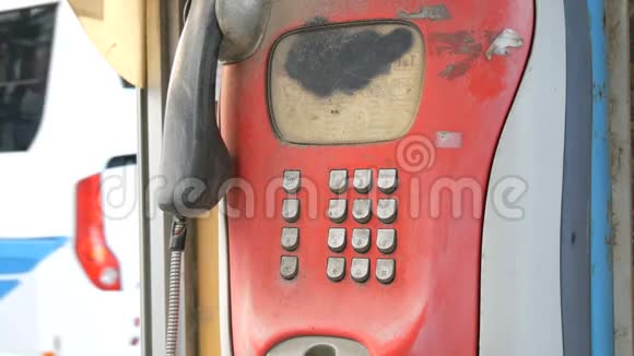 旧的破旧的红色电话设置在一条城市街道上电话亭里的老式电话视频的预览图