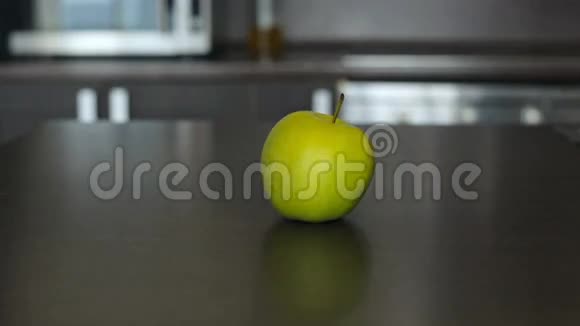 小女孩伸手在桌上拿一个青苹果视频的预览图