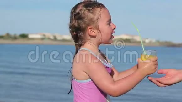 在海滩上喝橙汁的女孩视频的预览图