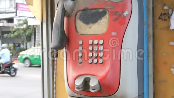 旧的破旧的红色电话设置在一条城市街道上电话亭里的老式电话视频的预览图