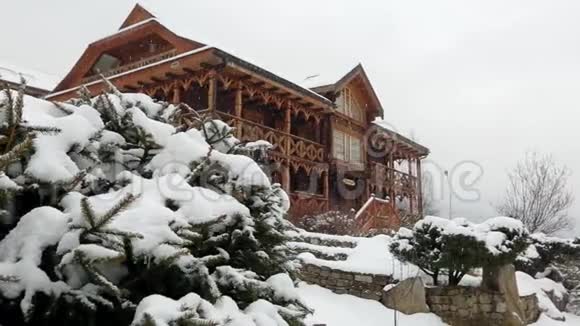 大雪时山村的木屋背景是针叶林落在原木上的雪视频的预览图
