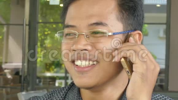 一位年轻的亚洲男性专业人士在智能手机上与同事聊天视频的预览图
