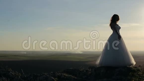 新娘和新郎在夕阳下的山岩上牵手视频的预览图