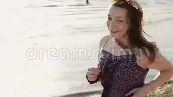 快乐的年轻女孩头发花在海滩上镜头微笑晴天视频的预览图