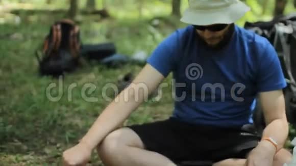 这个人控制着森林里的煤气燃烧器他坐在地上开始准备晚餐视频的预览图