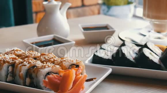 两套寿司卷在一个时尚装饰精美的咖啡馆在寿司旁边的桌子上有日本料理视频的预览图