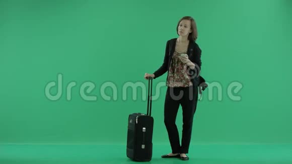 带手提箱的女游客正在打电话视频的预览图