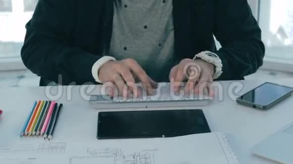 设计师的手在项目工作打字在笔记本电脑在明亮的现代办公室视频的预览图