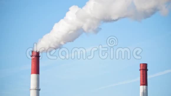 蓝天上的电厂烟囱从红管里喷出的白色蒸气视频的预览图