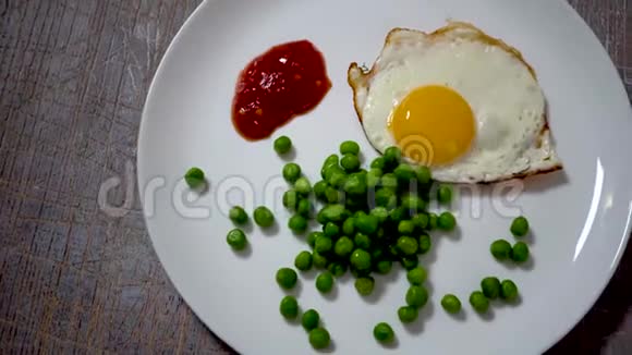 用豌豆和酱汁在白色盘子上炒鸡蛋视频的预览图