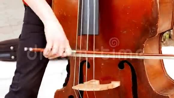 街头特写中拉小提琴的男孩的手视频的预览图