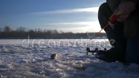 一个老渔夫在湖上过冬钓鱼冬季捕鱼冬季冰上钓鱼4K视频的预览图