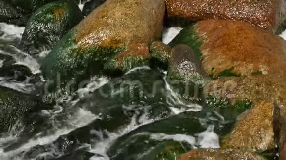 海浪拍打着海面上的岩石小浪和圆石视频的预览图