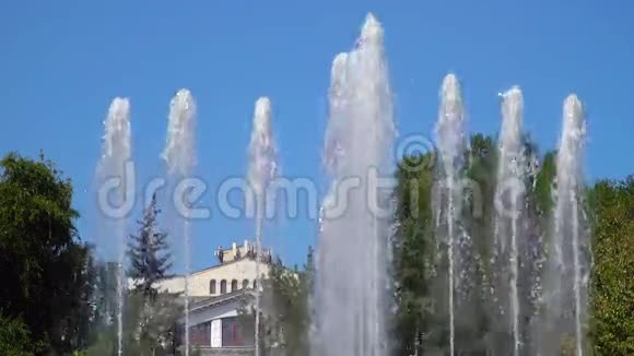 喷泉在建筑物和树木背景下的喷射视频的预览图