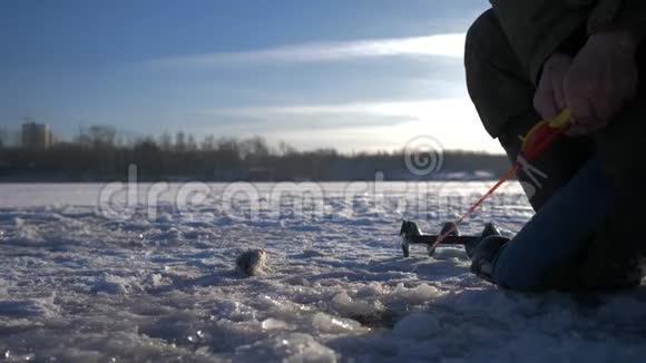 一个老渔夫在湖上过冬钓鱼冬季捕鱼冬季冰上钓鱼4K视频的预览图