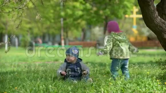 两个孩子在春天公园荡秋千视频的预览图