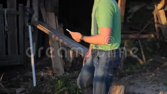 日落时打视频电话的年轻人一个男人坐在锯木厂视频的预览图