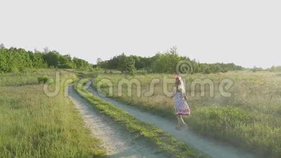 穿着红色图案的白色短裙跑过田野的小女孩视频的预览图