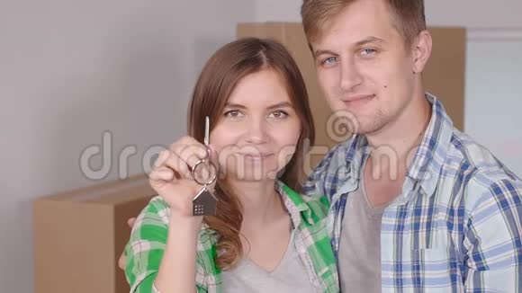 年轻的幸福夫妇带着盒子拿着平钥匙视频的预览图