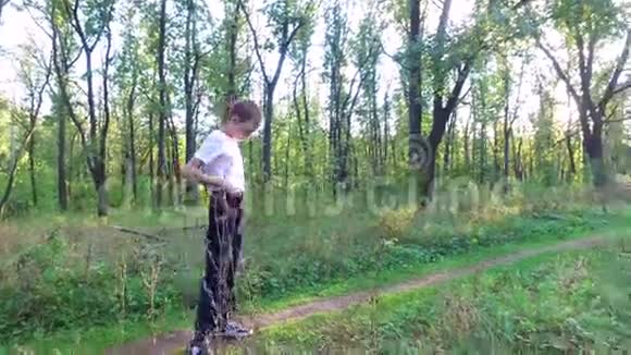 苗条的少年男孩在森林里完成蹲姿视频的预览图