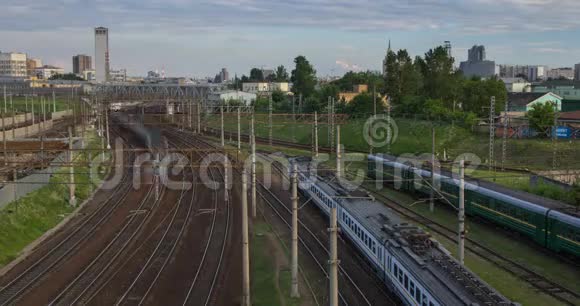 城市景观与许多铁路轨道的前景和通勤旅客列车的移动视频的预览图