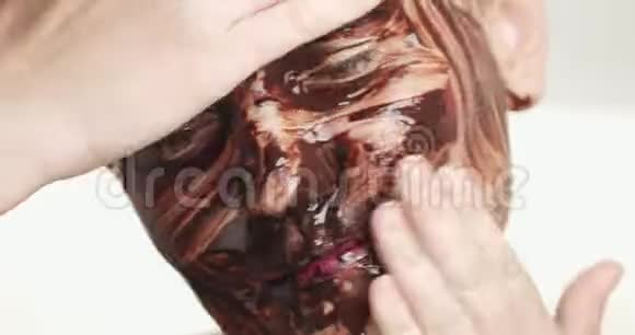 带巧克力面膜的女性会接受面部护理视频的预览图