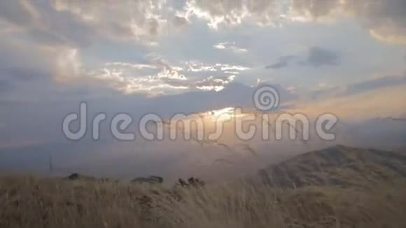 在滑翔伞的慢镜头下从黄色的草地上拍摄到的惊人的日落视频的预览图