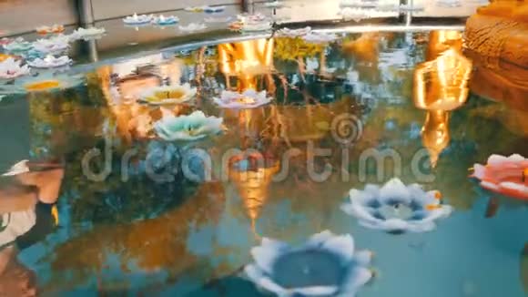 美丽的金色倒影在水中的佛像上各种蜡烛以莲花的形式漂浮着视频的预览图