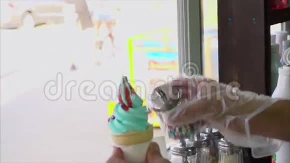 街头小贩用甜甜的彩星洒上冰淇淋华夫饼筒视频的预览图