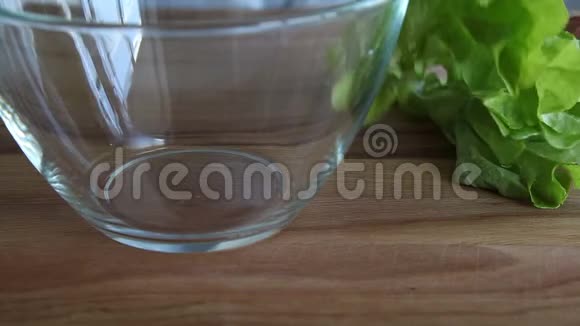 绿色生菜落入玻璃碗中视频的预览图