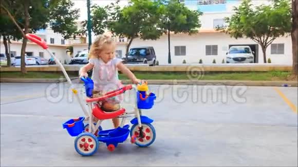 小红孩儿在操场上踩着三轮车视频的预览图