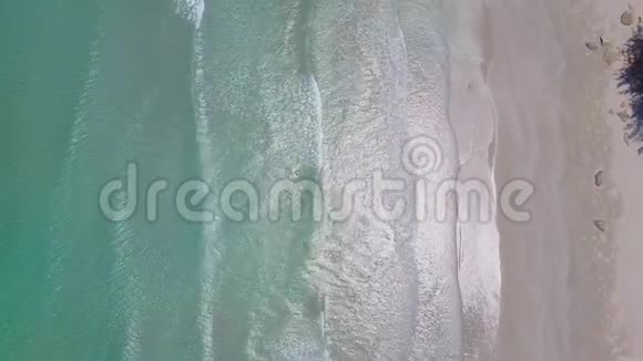 低飞在海滩上方蓝色的海洋美丽的海滩的空中景色视频的预览图