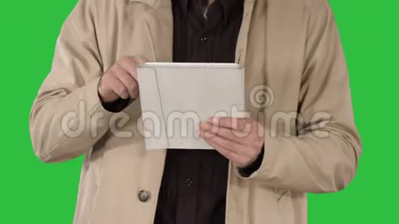 男人的手使用平板电脑在绿色屏幕上铬键视频的预览图