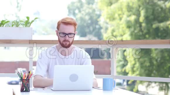 喝咖啡在笔记本电脑上在线工作坐在阳台室外视频的预览图