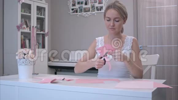 从粉红纸上剪蝴蝶的女人视频的预览图