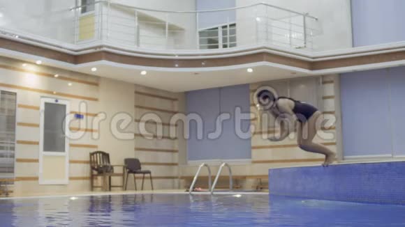 年轻的黑发女人潜入游泳池视频的预览图