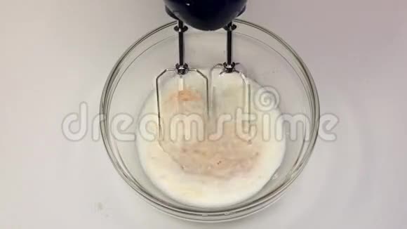 用搅拌机将鸡蛋与面粉和牛奶混合慢动作视频的预览图
