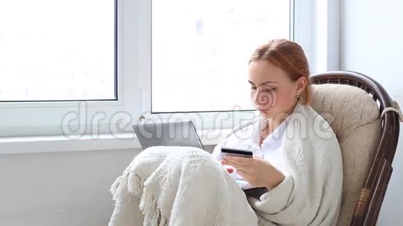 年轻女子在家用笔记本电脑上网购物视频的预览图