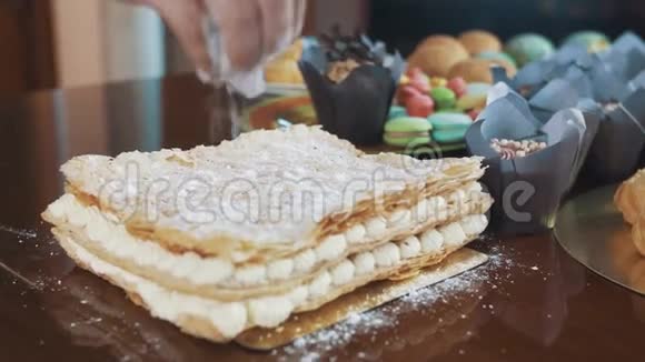 糖粉撒在桌上的分层蛋糕上上面有很多甜点视频的预览图