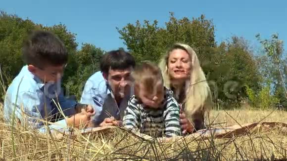 一家人正对着镜头躺在草地上视频的预览图