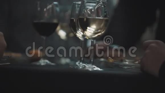 餐桌上的酒杯穿西装的男人吃肉串视频的预览图