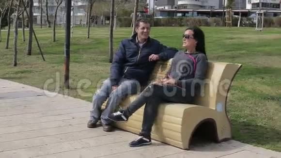 情侣们坐在公园长椅上聊天视频的预览图