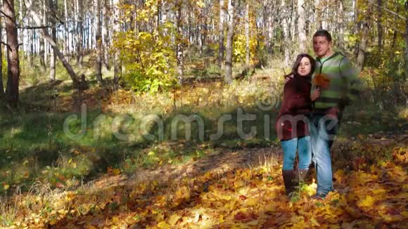 在秋天的森林里谈浪漫的年轻夫妇视频的预览图