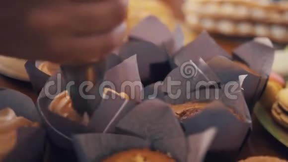 面包师装饰用紫色纸包裹着奶油的松饼视频的预览图