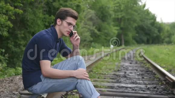年轻人在铁路上打电话视频的预览图