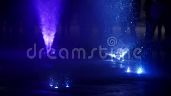 夜晚五彩缤纷的舞蹈喷泉在黑暗背景下缓慢运动的水喷流特写镜头无法辨认视频的预览图
