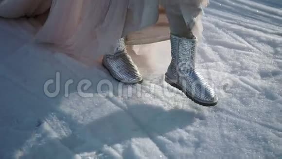 穿着长裙穿着银色鞋子的女人在冬日散步视频的预览图