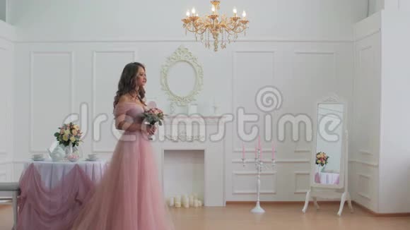 穿着粉色礼服的美丽新娘走在古典风格的房间里视频的预览图
