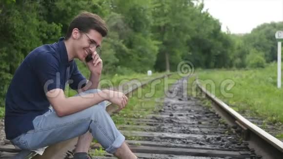 年轻人在铁路上打电话视频的预览图