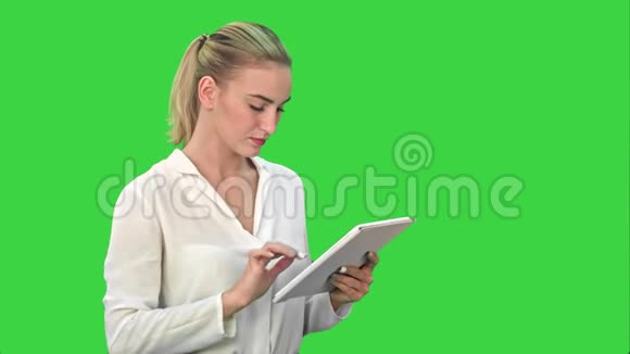 集中女商人站在一个绿色屏幕上的数字平板电脑Chroma键视频的预览图